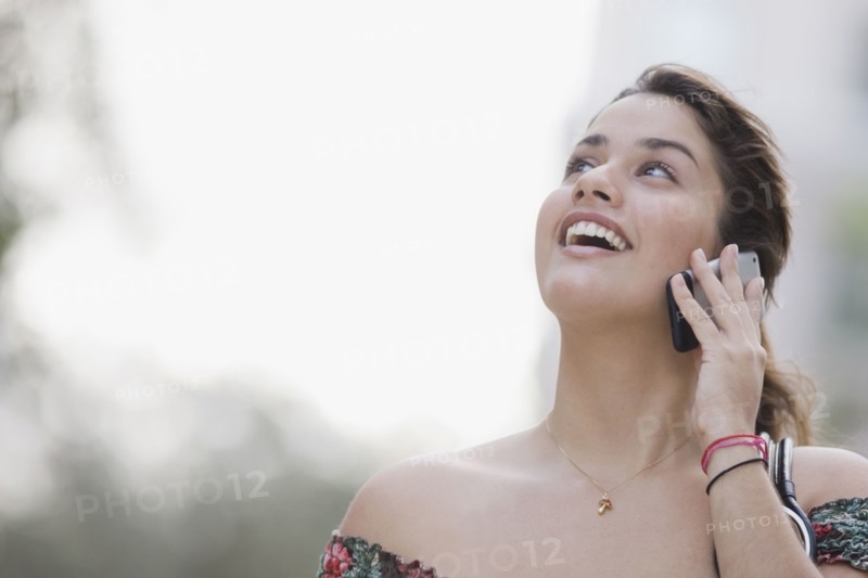Brazilian teenager talking cell phone looking up