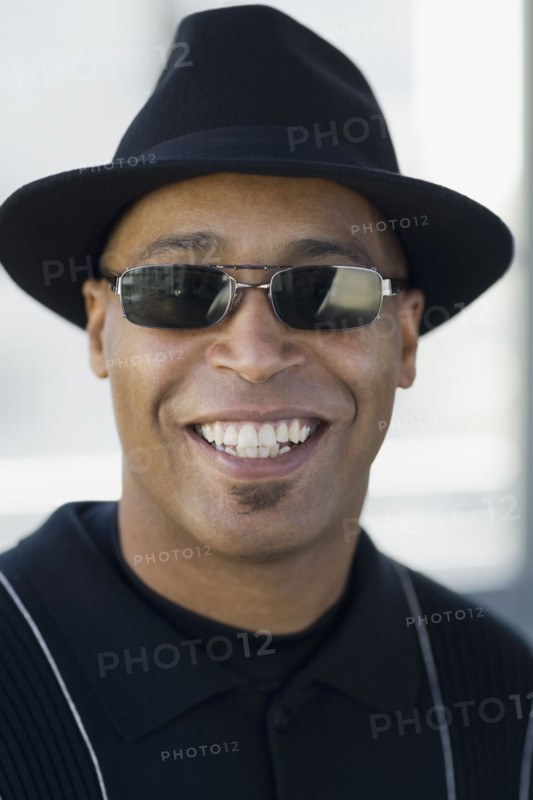 Close up of African man wearing sunglasses and hat