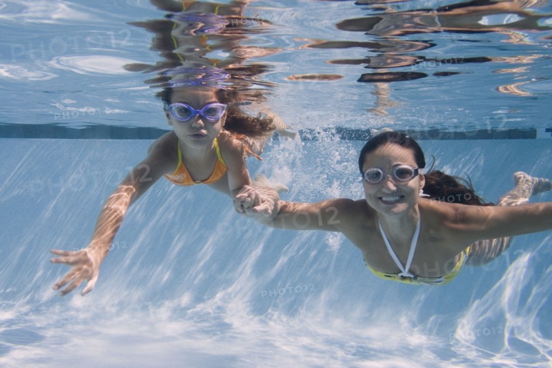 Mother and daughter swimming in swimming pool