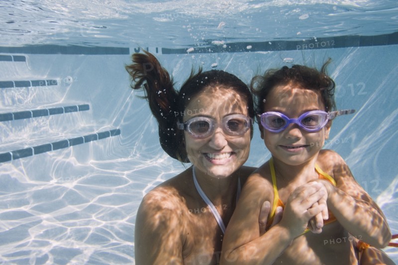 Mother and daughter swimming in swimming pool