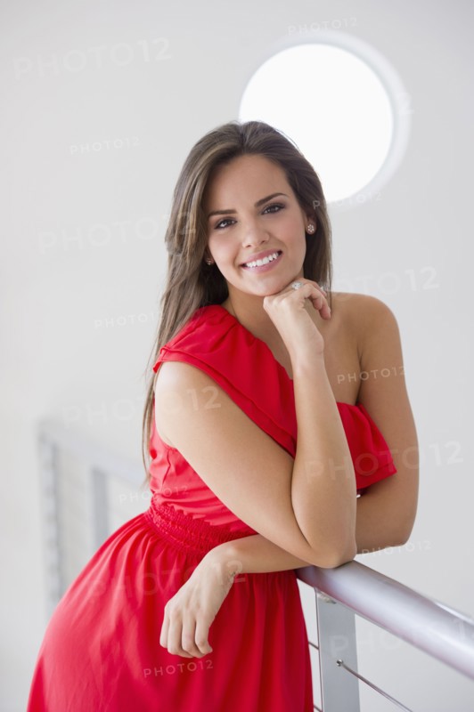 Glamorous Hispanic woman leaning on railing