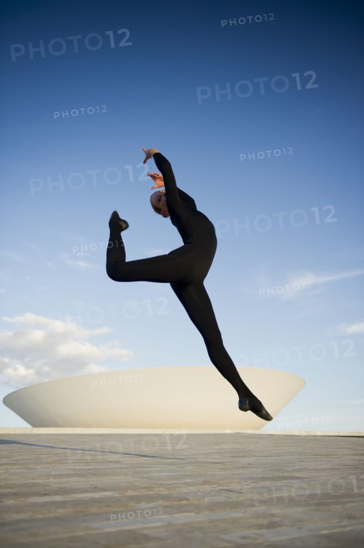 Brazilian dancer jumping in mid-air outdoors
