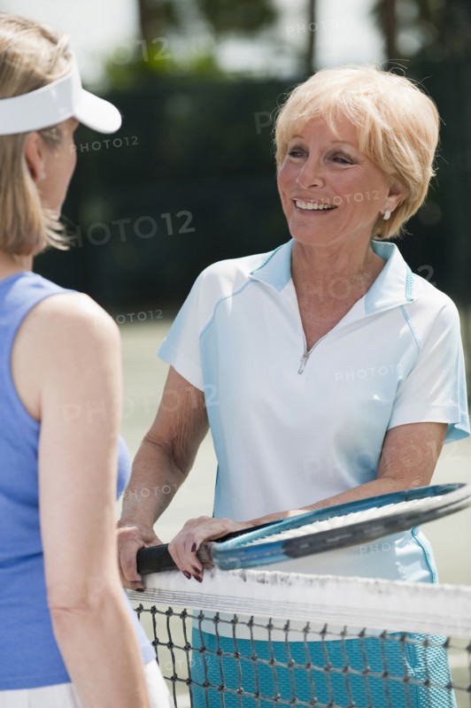 Caucasian women playing tennis