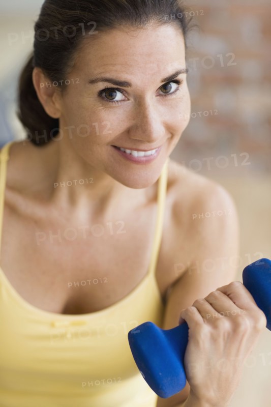 Hispanic woman exercising with dumbbells