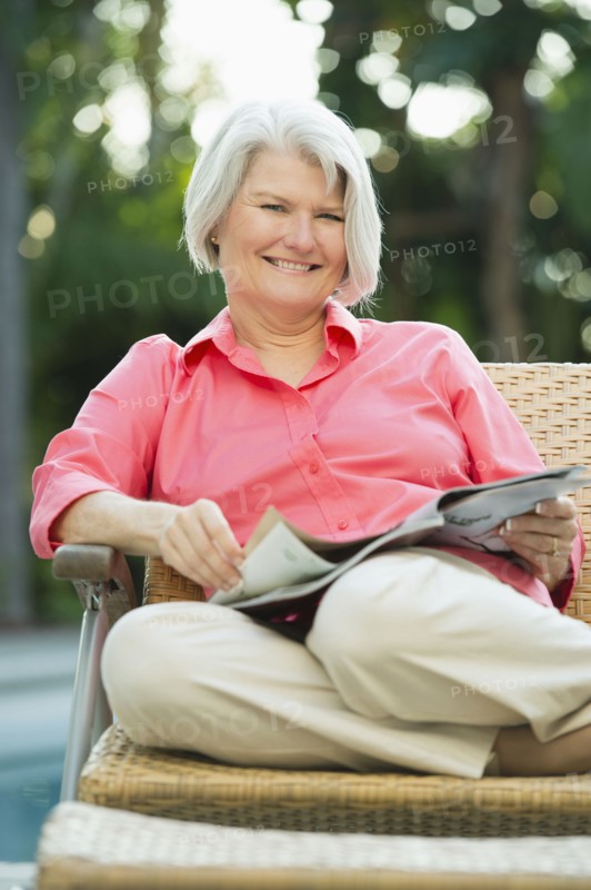 Caucasian woman reading magazine outdoors