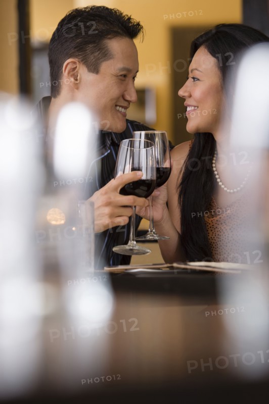 Couple toasting with red wine in restaurant