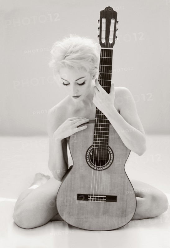 Nude Cuban woman holding guitar