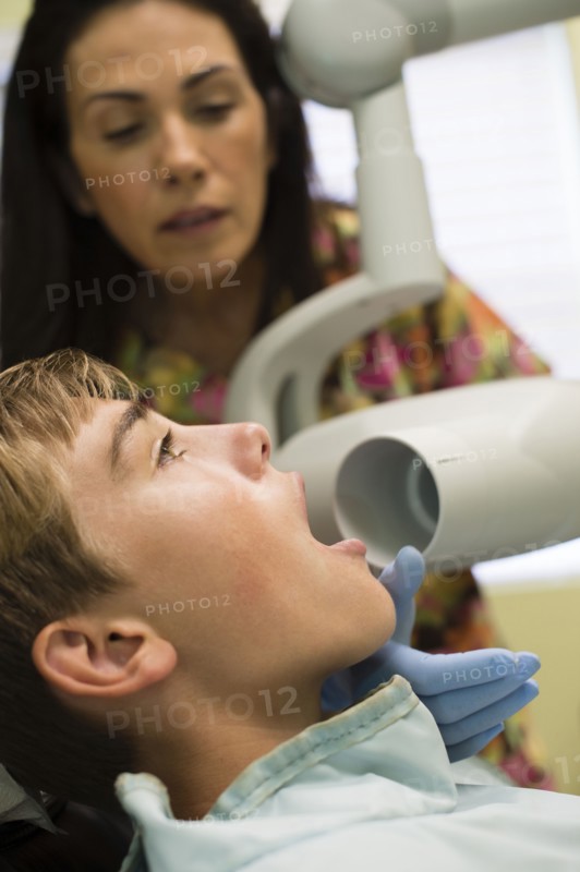 Nurse using equipment on dental patient