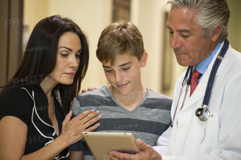 Mother and son using digital tablet with dentist