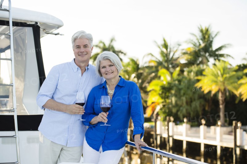 Older Caucasian couple having wine on boat deck