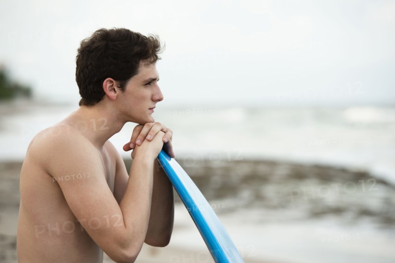 Hispanic man with surfboard on beach