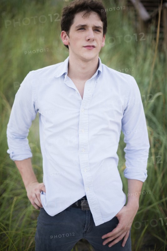 Hispanic man standing in tall grass