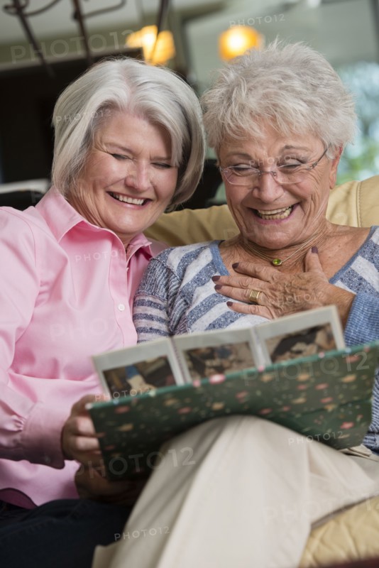 Senior Caucasian women looking at photo album