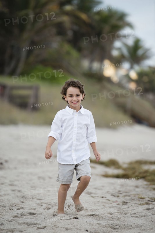 Hispanic boy walking on beach