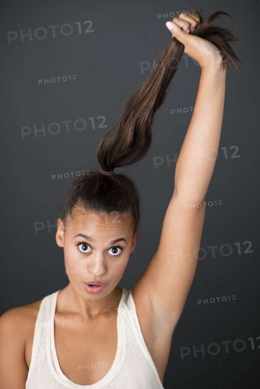 Mixed race woman pulling her ponytail
