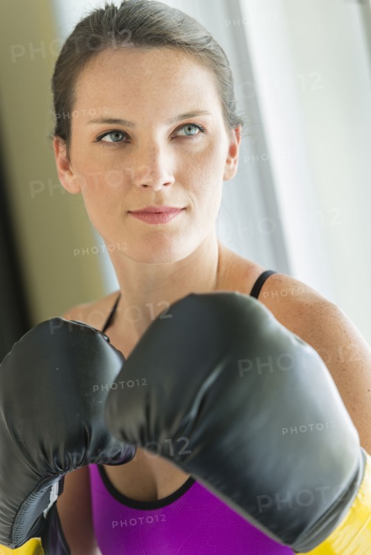 Caucasian woman with boxing gloves raised