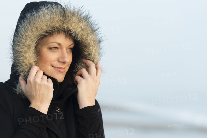 Caucasian woman wearing coat with fur hood outdoors