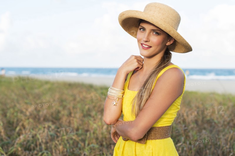 Caucasian woman wearing sun hat near beach