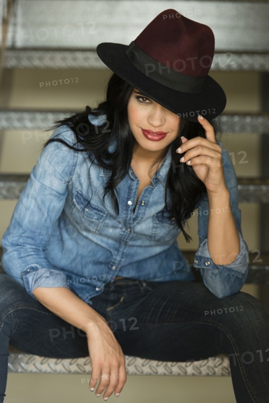 Glamorous Hispanic woman sitting on staircase
