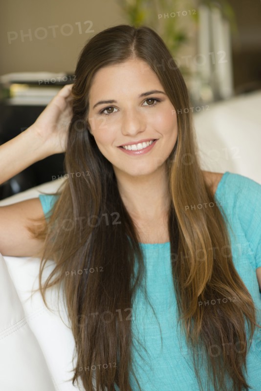 Caucasian woman with long hair sitting on sofa