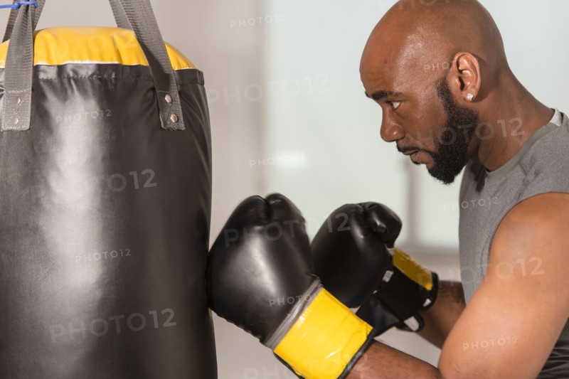 Black boxer training with punching bag