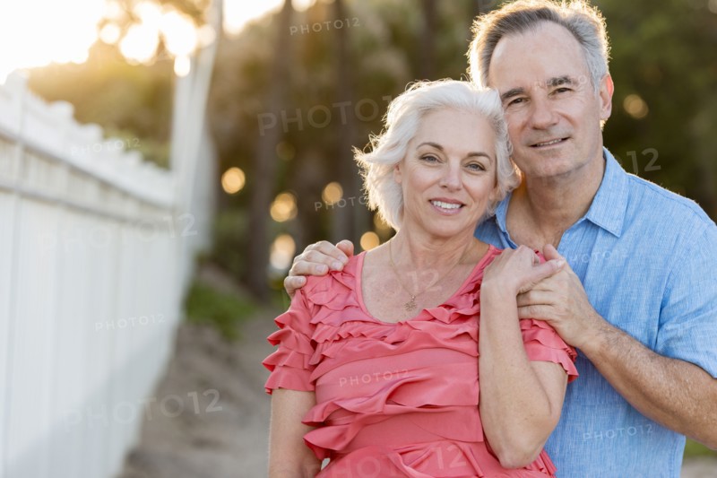 Older Caucasian couple hugging on beach