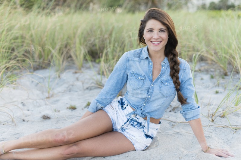 Hispanic woman sitting on beach