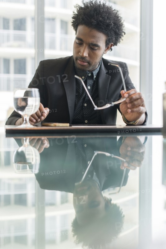 Hispanic businessman using cell phone at conference table
