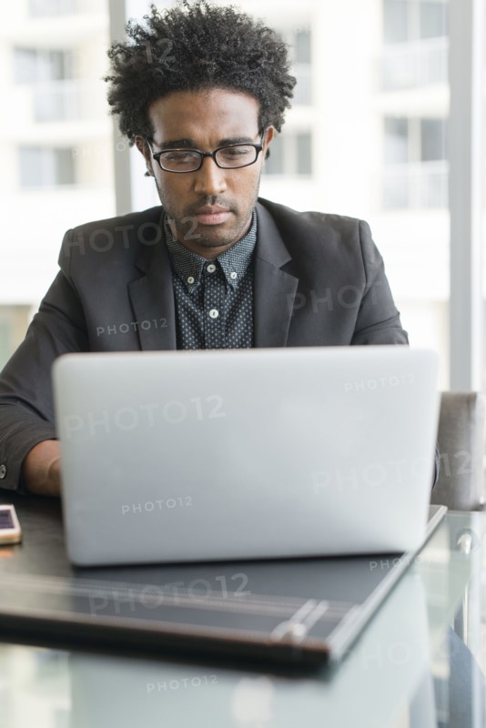 Hispanic businessman using laptop in office