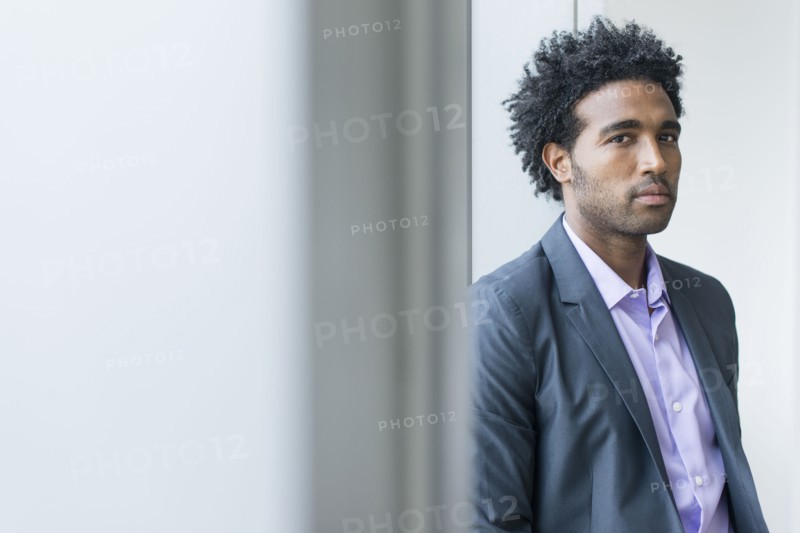 Serious Hispanic businessman at office window