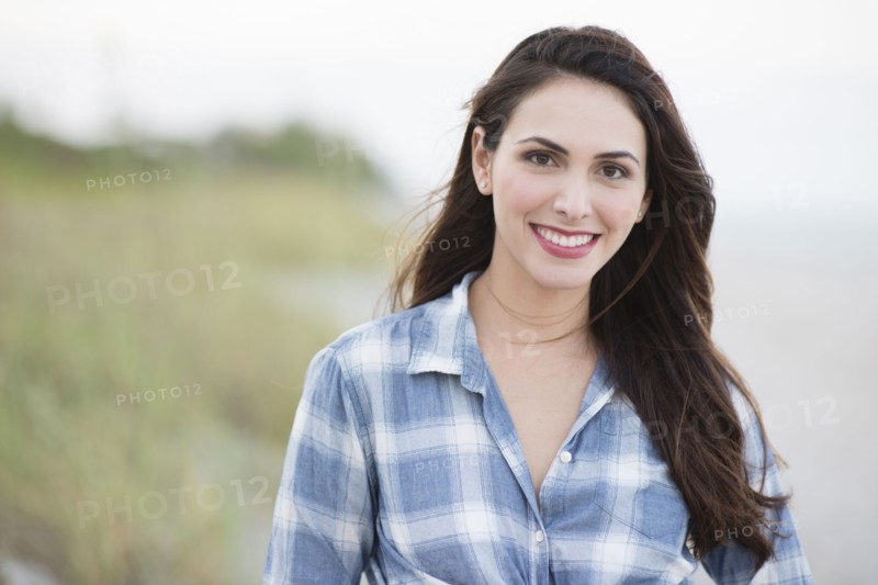 Hispanic woman smiling on beach
