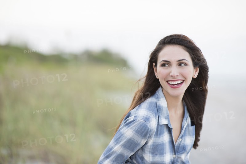 Hispanic woman smiling on beach