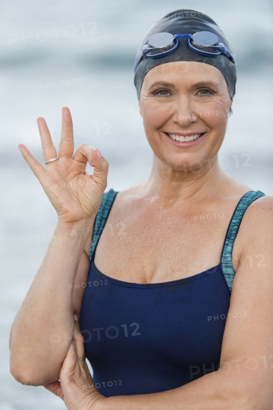 Caucasian swimmer making OK sign