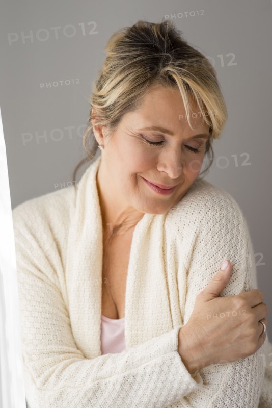 Caucasian woman wrapped in warm sweater
