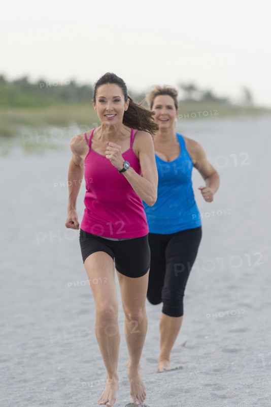 Caucasian women running on beach
