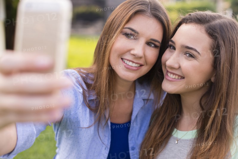 Mother and daughter taking selfie outdoors