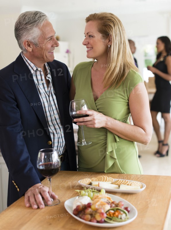 Caucasian couple drinking wine at party
