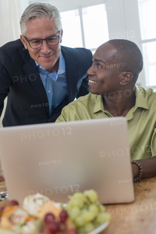 Businessmen using laptop at desk