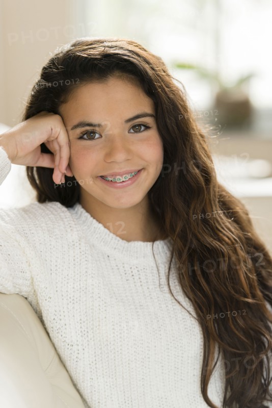 Mixed race girl smiling on sofa