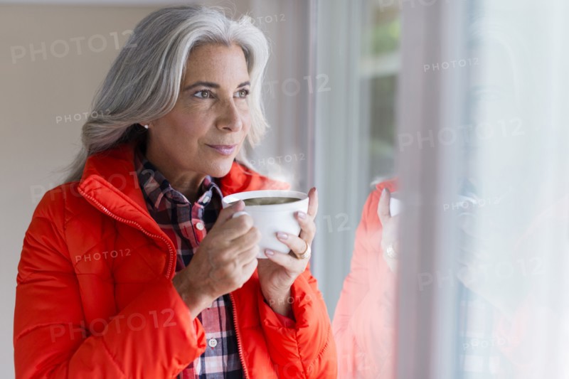 Caucasian woman drinking coffee in window
