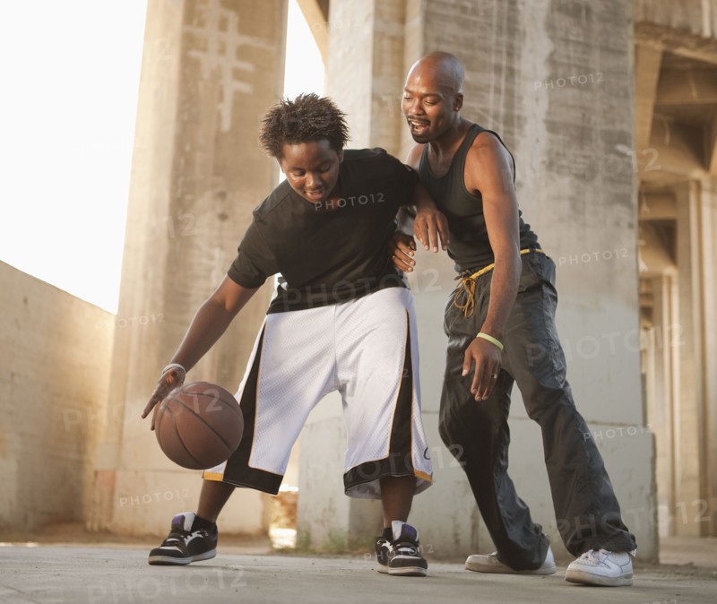 African father playing basketball with son