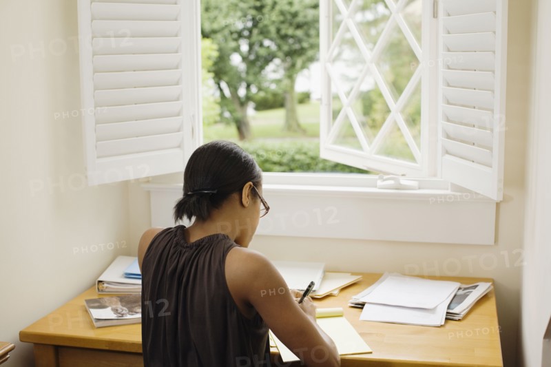 African woman writing at desk