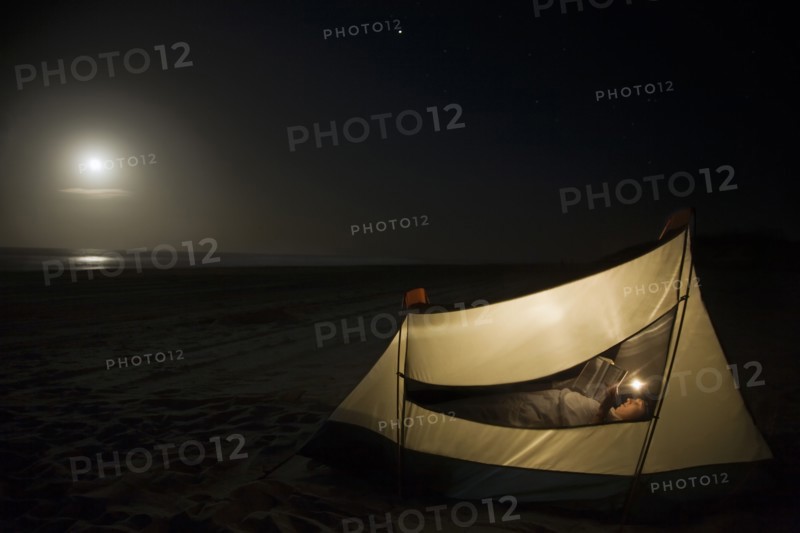 Caucasian man camping on beach
