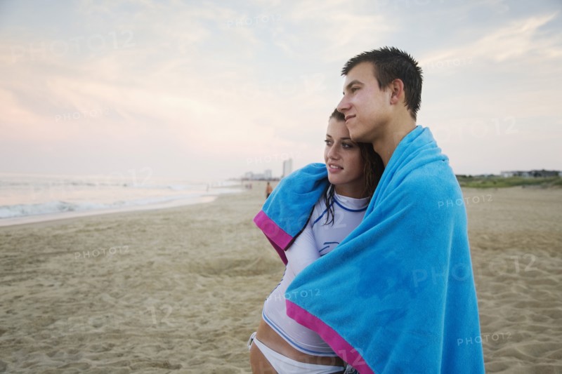 Caucasian couple hugging on beach