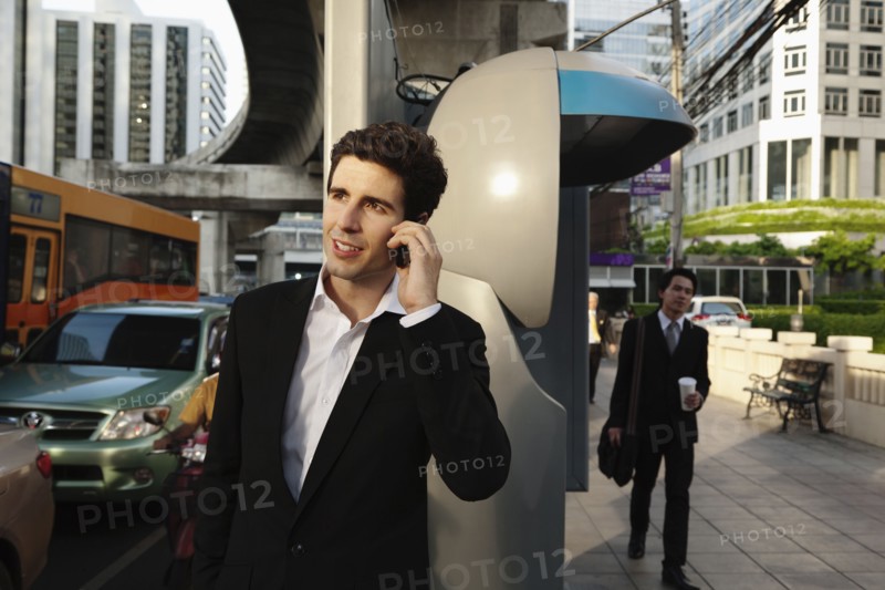 Caucasian businessman talking on cell phone outdoors
