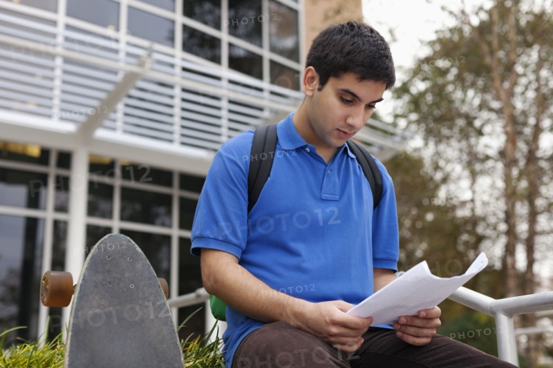 Middle Eastern student reading notes on campus