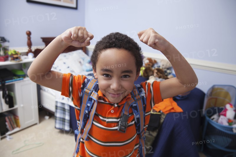 Mixed race boy wearing backpack in bedroom