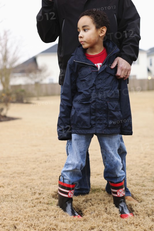 Father and son standing in field