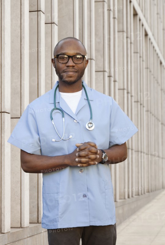 Black doctor standing on city street
