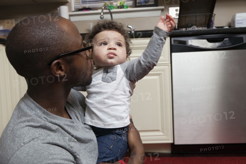 Father holding baby in kitchen